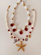 Load image into Gallery viewer, This handmade necklace features a beautiful blend of red and white freshwater and stone pearls, accented with summer-inspired charms. Adorned with a small starfish, a larger starfish, a shell, a silver elephant, and a silver starfish medallion, it captures the essence of coastal charm and sunny days. Perfect for adding a touch of beachy elegance to any outfit.