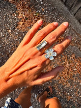 Load image into Gallery viewer, ABI crystal flower statement ring worn on the hand, featuring five large sparkling crystals set on a gold adjustable band.