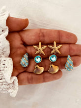 Load image into Gallery viewer, Ocean-inspired gold earrings with sparkling blue crystal.