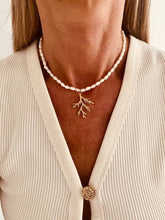 Load image into Gallery viewer, Elegant pearl necklace worn on the neck with an intricate coral branch pendant.