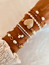Load image into Gallery viewer, Gold pearl bracelet styled on wrist demonstrating minimalist elegant everyday jewelry look