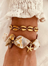Load image into Gallery viewer, Gold shell bracelet styled with outfit demonstrating refined everyday jewelry style