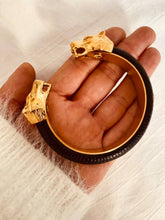 Load image into Gallery viewer, NYCOLE panther bracelet worn on the wrist, showcasing the bold sculptural design and luxurious combination of genuine leather with real gold plating.