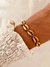 Load image into Gallery viewer, Gold shell bracelet in 18K PVD stainless steel shown from front angle highlighting elegant ocean inspired jewelry design