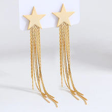 Učitaj sliku u preglednik galerije, Gold star tassel earrings with long sleek metal drops shown from front angle highlighting glamorous luxury statement jewelry