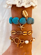 Load image into Gallery viewer, Gold starfish charm bracelet with turquoise lava stone hearts.