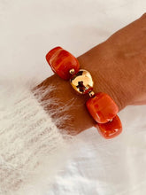 Load image into Gallery viewer, Coral Marble IZZA bracelet worn on the wrist, adding a bold pop of colour with glossy marbled resin beads.