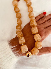 Učitaj sliku u preglednik galerije, Close-up_of_the_IZZA_Taupe_Marble_necklace_showcasing_glossy_marbled_resin_beads_in_warm_taupe_shades_finished_with_elegant_gold_details.