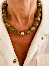 Učitaj sliku u preglednik galerije, IZZA Olive Marble necklace worn on the model, creating a bold everyday statement with glossy marbled resin beads and gold accents.