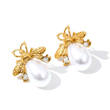 Učitaj sliku u preglednik galerije, Bee earrings with pearl detail displayed on neutral background highlighting feminine modern jewelry aesthetic