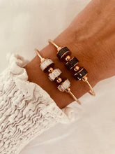 Load image into Gallery viewer, Rose gold roller bangle bracelet worn on wrist highlighting elegant modern jewelry style