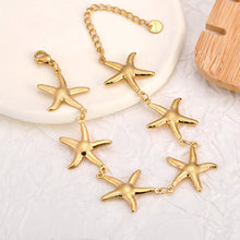 Load image into Gallery viewer, Gold plated stainless steel starfish bracelet displayed from front angle highlighting ocean inspired elegant jewelry design