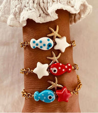 Load image into Gallery viewer, Fish charm bracelets stacked on wrist showing trendy layering jewelry style