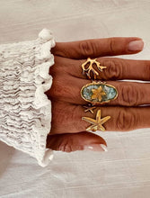 Load image into Gallery viewer, Close-up of turquoise marbled center and gold starfish showcasing artistic jewelry detail