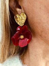 Load image into Gallery viewer, YNES burgundy flower statement earrings worn on the ear, showcasing a sculptural resin flower suspended from a textured gold heart for an elegant statement look.