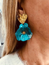 Load image into Gallery viewer, YNES turquoise flower statement earrings worn on the model, combining a bold resin flower with a textured gold heart stud.