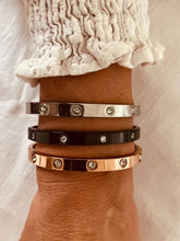 Load image into Gallery viewer, Zircon bangle bracelet layered with other bracelets on wrist showing modern stacking jewelry style