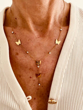 Load image into Gallery viewer, Close up on model neck showing how butterfly charms and dangling detail sit naturally along the neckline