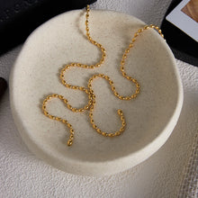 Load image into Gallery viewer, Flat lay of gold stainless steel Y-drop necklace with delicate pearl fringe accents.
