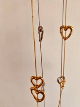 Load image into Gallery viewer, Side angle of long stainless steel heart necklace showing chain length and design