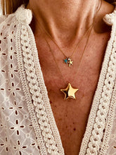 Load image into Gallery viewer, Gold stainless steel star pendant necklace worn on model styled with a rock glam outfit to showcase real life fit and statement effect