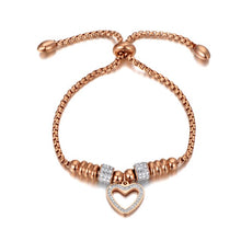 Load image into Gallery viewer, Bracelet is made of stainless steel and comes in two colours: rose gold and silver. It is richly adorned with two rollers and heart charm. Both rollers and heart are decorated with cubic zirconia. The length is adjustable with a small ball. The bracelet is three times rose gold plated.