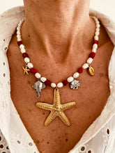 Load image into Gallery viewer, This handmade necklace features a beautiful blend of red and white freshwater and stone pearls, accented with summer-inspired charms. Adorned with a small starfish, a larger starfish, a shell, a silver elephant, and a silver starfish medallion, it captures the essence of coastal charm and sunny days. Perfect for adding a touch of beachy elegance to any outfit.
