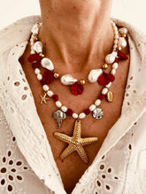 Load image into Gallery viewer, This handmade necklace features a beautiful blend of red and white freshwater and stone pearls, accented with summer-inspired charms. Adorned with a small starfish, a larger starfish, a shell, a silver elephant, and a silver starfish medallion, it captures the essence of coastal charm and sunny days. Perfect for adding a touch of beachy elegance to any outfit.
