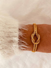 Load image into Gallery viewer, Side angle of knot cuff bracelet showing adjustable design and sleek structure
