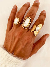Load image into Gallery viewer, Close-up of the adjustable AFON statement ring featuring a natural freshwater pearl and elegant hammered gold finish styled with other Bernat Jewelry rings.
