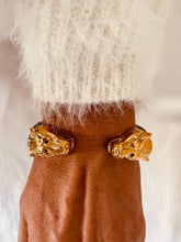 Load image into Gallery viewer, Close-up of the NYCOLE bracelet highlighting the polished gold panther heads, premium black leather detail and elegant open cuff construction.
