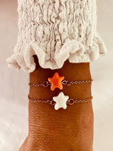 Load image into Gallery viewer, Gold plated stainless steel bracelet with ceramic star charm worn on wrist showcasing minimalist ocean inspired jewelry
