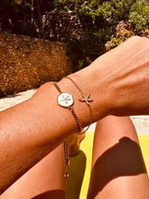 Load image into Gallery viewer, Crystal sea star bracelet layered with other jewellery.

