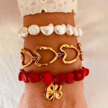 Load image into Gallery viewer, Red bracelet with sculptural clover pendant.
