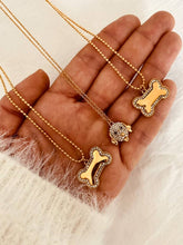 Load image into Gallery viewer, Close-up of the AKIKO dog bone necklace highlighting the elegant zircon border and polished gold finish designed for every dog lover.
