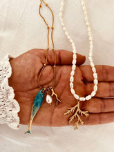 Load image into Gallery viewer, Close-up of the FAUZIA necklace showcasing the fish, pearl and coral charms
