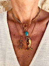 Load image into Gallery viewer, Close-up of the Cortie gold fish necklace layered with ocean-inspired necklaces from Bernat Jewelry.
