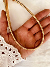 Load image into Gallery viewer, Gold plated stainless steel snake chain necklace shown from front angle highlighting smooth fluid design and minimalist luxury aesthetic
