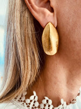 Load image into Gallery viewer, Gold leaf earrings worn on the ear.
