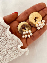 Load image into Gallery viewer, Side angle of hammered circle earrings showing irregular shape and polished finish
