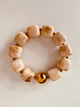 Load image into Gallery viewer, Close-up of the IZZA Cream Marble bracelet featuring glossy cream marbled resin beads and a polished gold statement bead.
