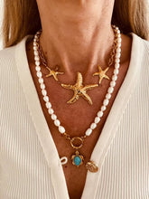 Load image into Gallery viewer, Gold starfish necklace worn as a bold summer statement piece.
