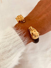 Load image into Gallery viewer, Luxury black leather cuff bracelet with gold panther heads designed for women who love timeless statement jewelry with a bold character.
