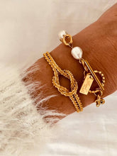Load image into Gallery viewer, Knot cuff bracelet layered with other jewelry showing trendy stacking style
