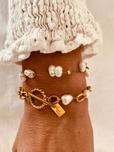 Load image into Gallery viewer, Pearl bracelet styled with other bracelets on wrist demonstrating modern stacking jewelry trend
