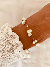 Load image into Gallery viewer, Freshwater pearl bracelet styled on wrist in natural light highlighting subtle shine and texture
