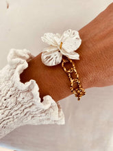 Load image into Gallery viewer, Woman wrist wearing bracelet with large pearl flower and gold chain links
