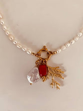 Load image into Gallery viewer, Close-up of handmade pearl necklace featuring coastal inspired charms and elegant gold detailing
