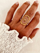 Load image into Gallery viewer, Gold plated stainless steel statement ring featuring a raised starfish on a blush-toned background
