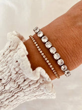 Load image into Gallery viewer, Tennis bracelet layered with other jewelry creating modern stacked look
